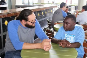 Man speaking with younger kid with ASAS blue shirt