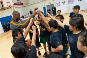 Group of kids with fist up in the air with Kobe Bryant