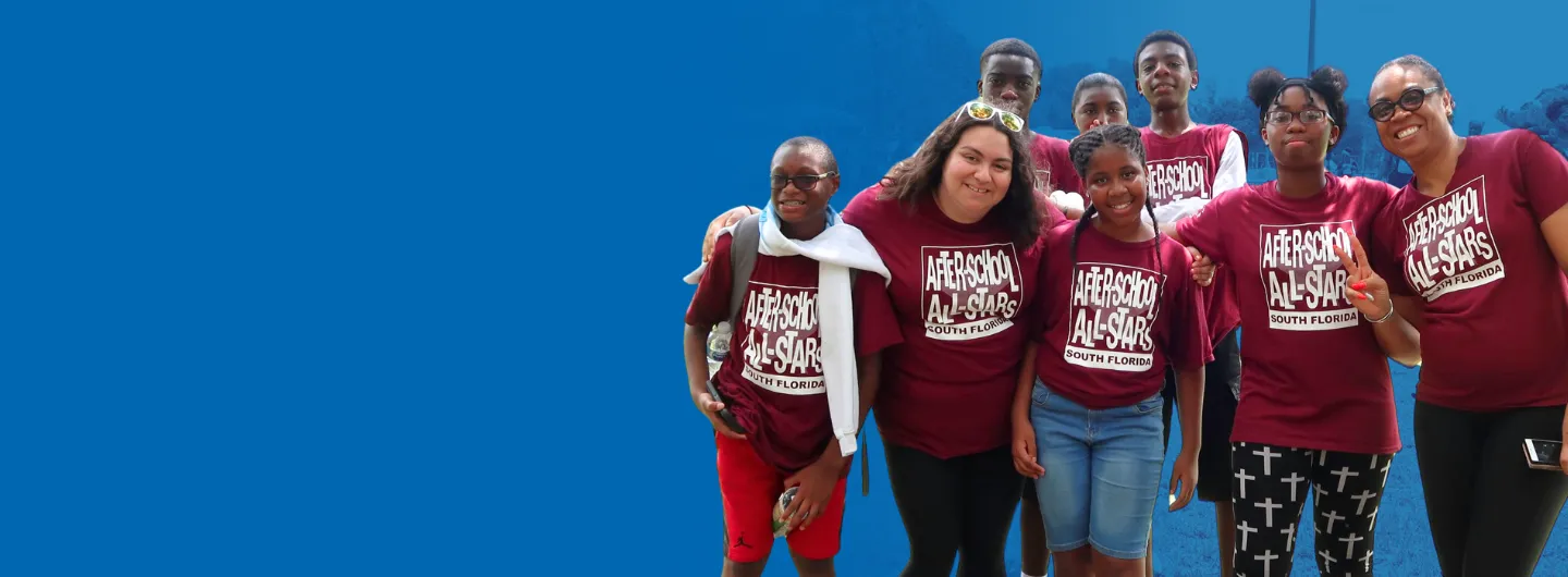 After-School All-Stars South Florida students and mentors standing together and smiling at a community event.